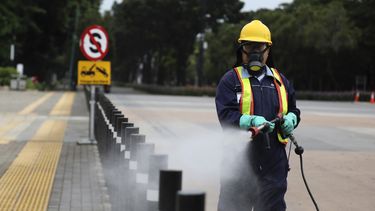 Un operario esparce desinfectante en una acera en el Senayan Sports Complex ante el brote de coronavirus, en Yakarta, Indonesia, el 26 de marzo de 2020.&nbsp;