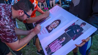 Varios estudiantes firman un poster con fotografías de Joaquín Oliver, una de las 17 víctimas mortales de la masacre de Parkland, Florida.
