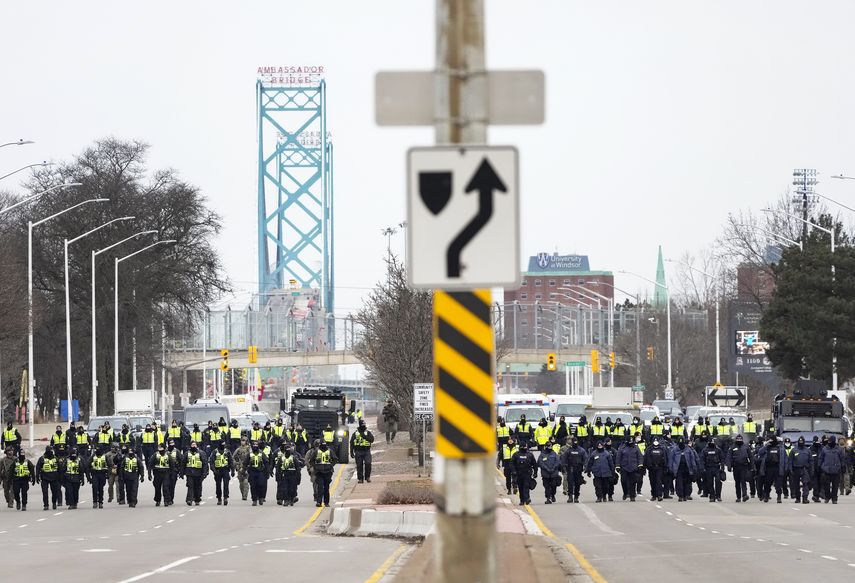 Policías canadienses avanzan para desalojar a manifestantes que bloquearon el acceso al Puente Ambassador, que une a EEUU con Canadá, en Windsor, Ontario, el domingo 13 de febrero de 2022.&nbsp;