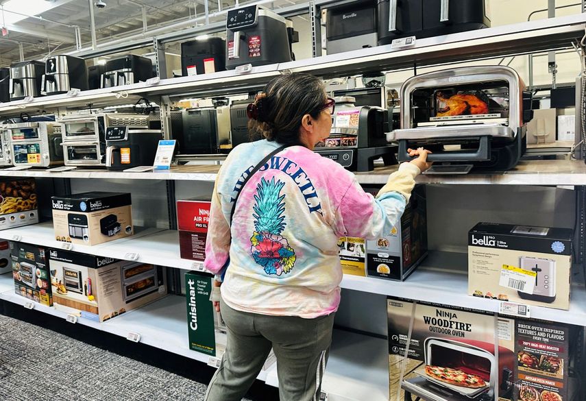 Una mujer revisa un minihorno en&nbsp; una tienda en Estados Unidos.