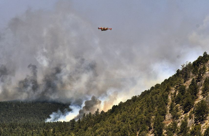 Un avión para combatir incendios vuela sobre un incendio forestal el miércoles 4 de mayo de 2022, cerca de la ciudad de Las Vegas, Nuevo México.&nbsp;