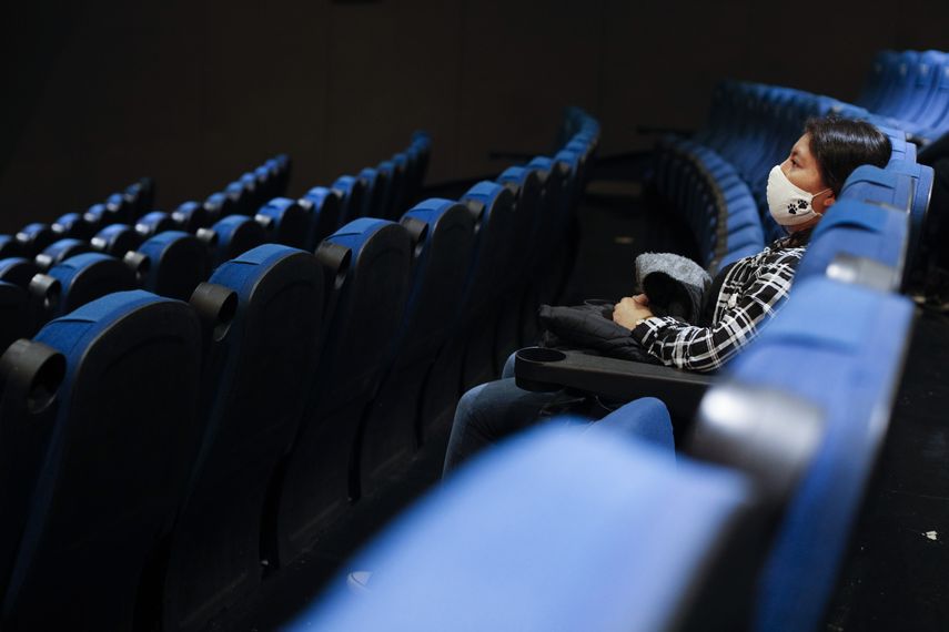 Una asistente espera el comienzo de una película en un cine acompañada de pocos espectadores en la Cineteca Nacional en la Ciudad de México. 