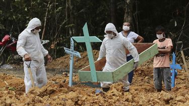 En esta imagen, tomada el 16 de abril de 2020, enterradores, vestidos con equipos de protección, preparan una tumba en el cementerio Nossa Senhora Aparecida para una mujer que se cree que murió por COVID-19, en Manaos, en el estado brasileño de Amazonas. 