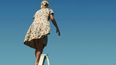 El cartel que representa el evento muestra a una mujer subida a una escalera plegable en un paisaje desértico y mirando hacia el horizonte. (CORTESÍA/uai.cl)