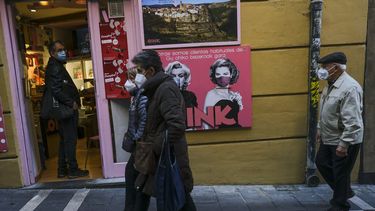 Unas personas con cubrebocas debido al coronavirus caminan por una calle en Pamplona, norte de España, el 20 de noviembre de 2020.