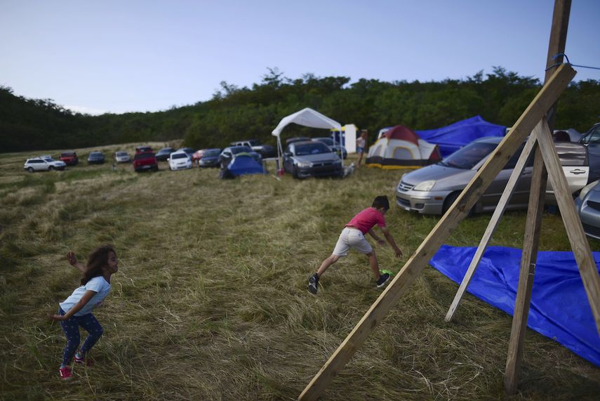 En esta foto del 10 de enero de 2020, ni&ntilde;os juegan en un campo de heno donde los habitantes de Guayanilla, Puerto Rico, se han instalado despu&eacute;s del terremoto y las r&eacute;plicas que da&ntilde;aron sus viviendas. Un terremoto de magnitud 6,4 que destruy&oacute; o inutiliz&oacute; cientos de viviendas en el suroeste de Puerto Rico genera preocupaci&oacute;n sobre el destino de las familias que quedaron sin techo. La isla a&uacute;n encara la reconstrucci&oacute;n despu&eacute;s del hurac&aacute;n Mar&iacute;a de hace dos a&ntilde;os.&nbsp;