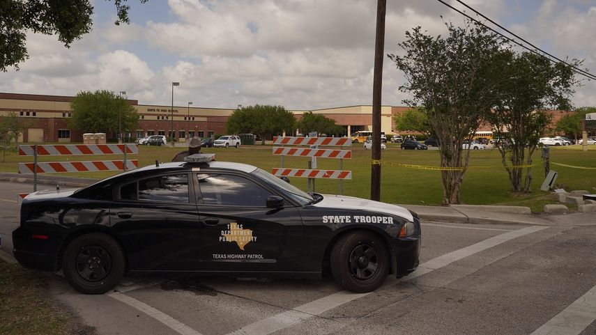 Un auto policial de Texas bloquea la entrada a la Escuela Secundaria Santa Fe, donde el viernes un pistolero disparó contra numerosas personas causando 10 muertes y 13 heridos.