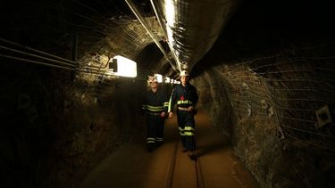 Dos científicos caminan por un túnel de una vieja mina de oro, a un kilómetro y medio (una milla) de profundidad, en Lead (Dakota del Sur), donde funciona un centro de investigaciones que trata de encontrar materia oscura en las profunidades de la Tierra. Foto del 8 de diciembre del 2019. La materia oscura constituye la mayor parte de la masa del universo, pero nunca ha sido vista.&nbsp;