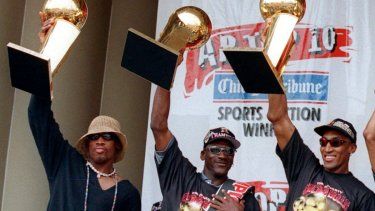 De izquierda a derecha, Dennis Rodman, Michael Jordan y Scottie Pippen, exjugadores de los Bulls de Chicago, sostienen tres de los trofeos del equipo, durante una ceremonia realizada el 16 de junio de 1997.