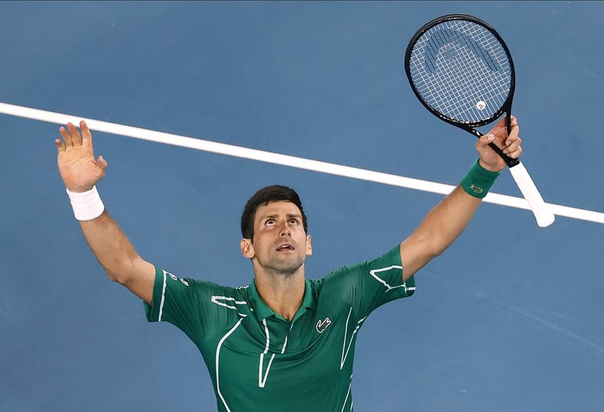 El tenista serbio Novak Djokovic celebra tras derrotar al suizo Roger Federer en su partido de semifinales del Abierto de Australia en Melbourne, Australia, el jueves 30 de enero de 2020.