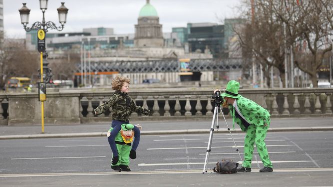 Personas vestidas para el D&iacute;a de San Patricio se toman fotos en el centro de Dubl&iacute;n, el martes 17 de marzo de 2020.&nbsp;