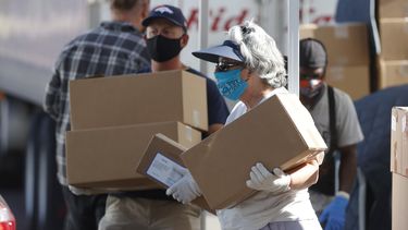 Una mujer entrega alimentos y ayuda a personas necesitadas en Denver.