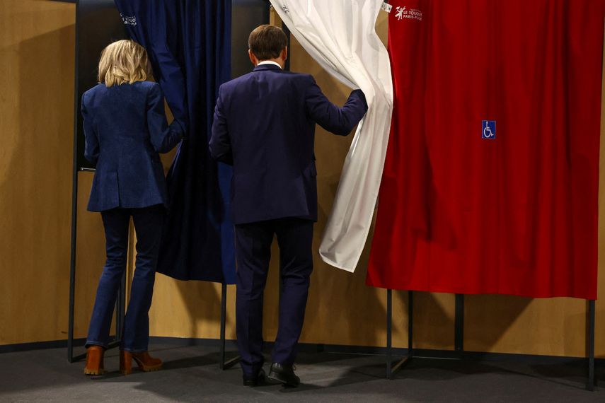 El presidente francés Emmanuel Macron y su esposa Brigitte Macron entran en una cabina de votación durante las elecciones europeas, el domingo 9 de junio de 2024&nbsp;