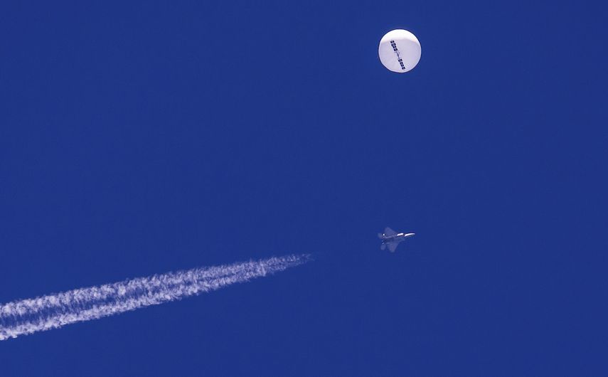 En esta foto provista por Chad Fish, un gran globo vuela sobre el Atlántico cerca de la costa de Carolina del Sur, y un avión de combate con su estela aparece por debajo, 4 de febrero de 2023.