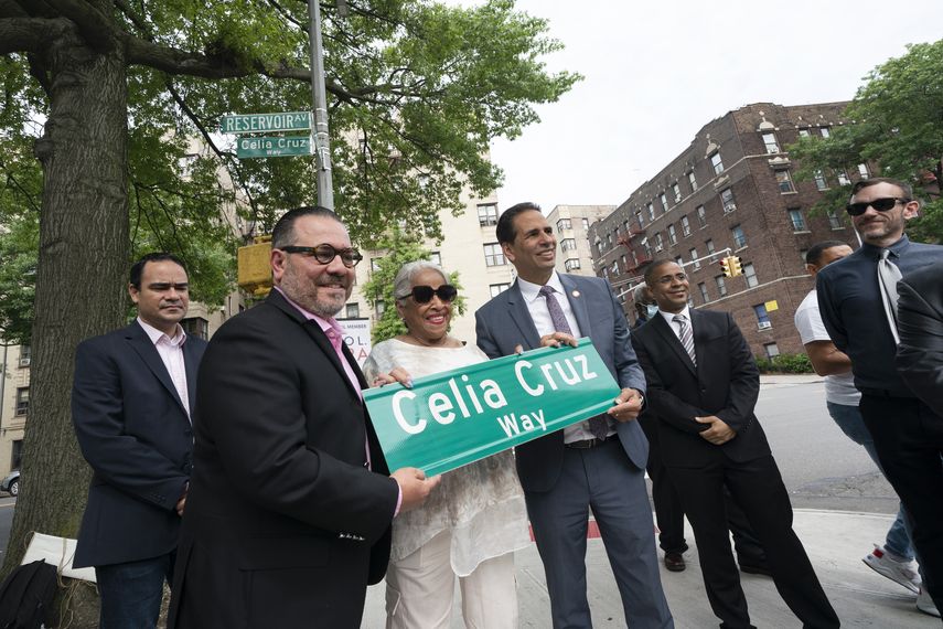 Omer Pardillo, exmanager de Celia Cruz, a la izquierda, Ruth Sánchez Laviera, quien fue amiga de la difunta cantante cubana, y el concejal de Nueva York Fernando Cabrera, a la derecha, sostienen un letrero con las palabras Celia Cruz Way, el miércoles 2 de junio del 2021 en una calle de Nueva York.&nbsp;