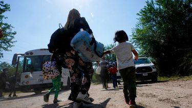 Una familia de migrantes venezolanos se dirige hacia un autobús de la Patrulla Fronteriza después de que cruzaran con otras personas de México hacia Estados Unidos y se entregaran a las autoridades, en Del Rio, Texas.