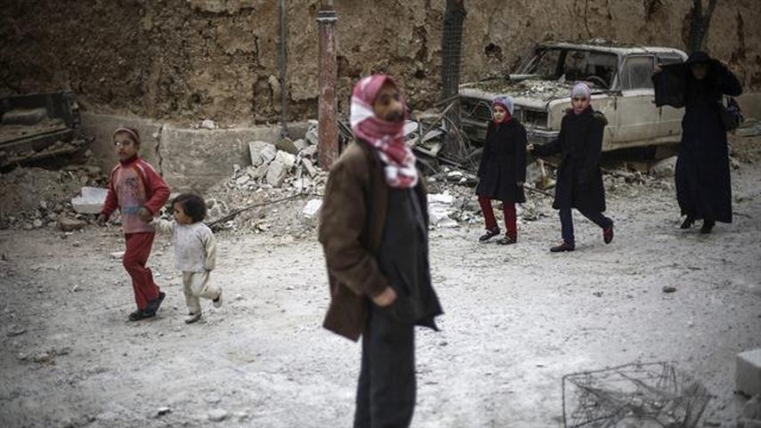 Adultos y niños, en medio de los derrumbes tras bombardeos contra el Estado Islámico en Siria. (EFE)