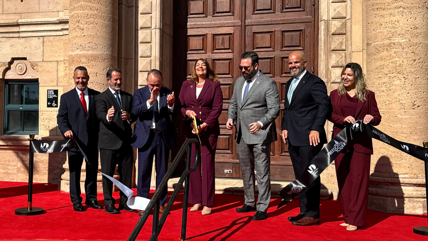 La presidenta del Miami Dade College, Madeline Pumariega, realiza el corte de cinta en el acto de reapertura de la Torre de la Libertad en Miami. La acompañan personalidades del sur de la Florida.