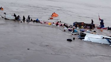 Esta imagen, difundida por el COER (Centro de Operaciones de Emergencia Regional), muestra a personas alrededor de los restos de una embarcación accidentada en el puerto de Iparia, en el departamento de Ucayali, en la selva central de Perú, el 1 de diciembre de 2025.