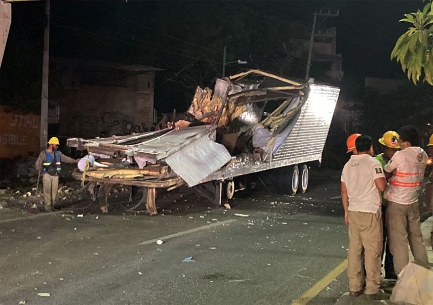 Los trabajadores retiran el contenedor del remolque de un camión que se estrelló con migrantes a bordo durante un accidente de tránsito en Tuxtla Gutiérrez, estado de Chiapas, México, el 9 de diciembre de 2021.
