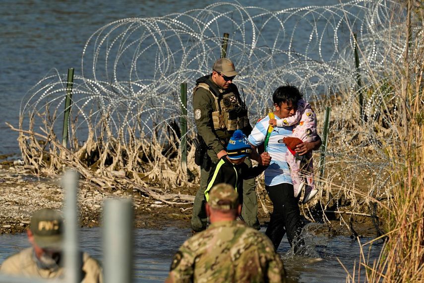 Un inmigrante ingresa por la frontera a Estados Unidos en Eagle Pass, Texas, acompañado de dos menores. 