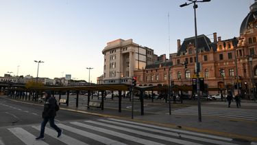 Un hombre cruza la calle junto a una parada de autobús vacía frente a la estación de tren Constitución en Buenos Aires el 9 de mayo de 2024, durante una huelga general convocada por la Confederación General del Trabajo (CGT). El presidente de Argentina, Javier Milei, afronta este jueves la segunda huelga general contra el brutal ajuste de su gobierno, que paraliza los servicios de transporte terrestre, marítimo y aéreo, así como las instituciones educativas, financieras y comerciales en todo el país.