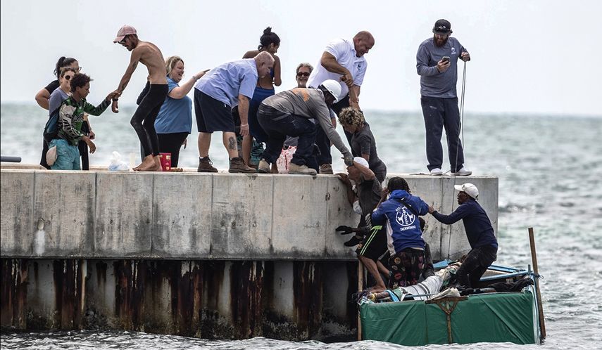 Personas ayudan a migrantes cubanos a llegar a la costa de Cayo Hueso, Florida.