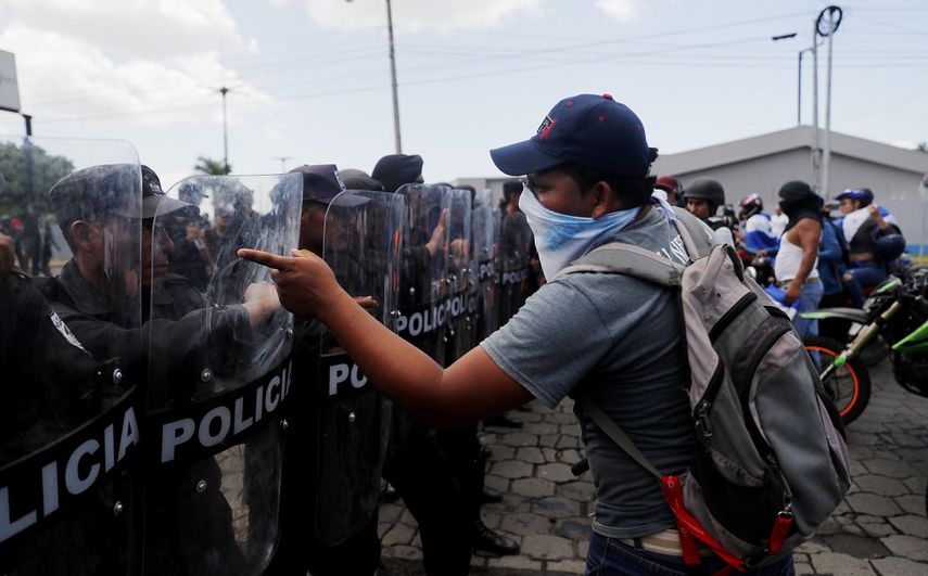 Manifestantes&nbsp;recriminan a los policías antimotines que bloqueen el paso de una marcha contra Daniel Ortega, a quien acusan por la muerte de cientos de personas en protestas contra su régimen.