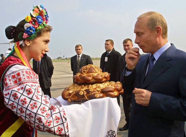 Una mujer vestida con el traje nacional ucraniano le da la bienvenida al presidente ruso, Vladimir Putin, con pan y sal en el aeropuerto de Zaporizhye, a unos 568 kilómetros (352 millas) al oeste de la capital de Ucrania, Kiev, el 6 de octubre de 2002. 
