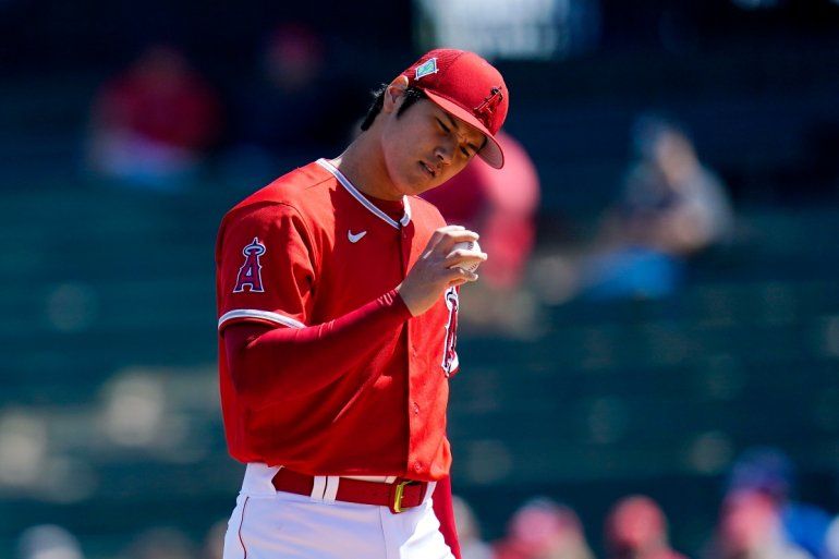 El pitcher de los Angelinos de Los &Aacute;ngeles Shohei Ohtani revisa una pelota durante la primera entrada del juego de pretemporada contra los Reales de Kansas City en la MLB