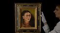 Una miembro del personal posa con el autorretrato de 1949 Diego y yo de Frida Kahlo en la casa de subastas Sothebys en Londres, el 21 de octubre de 2021. Bellas Artes de México investiga quema de dibujo de Kahlo.