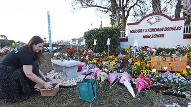 Una vecina de Parkland deposita flores frente al instituto Marjory Stoneman Douglas, en Broward, al norte de Miami.
