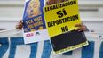 Fotografia de archivo de una mujer que sostiene un cartel en contra de la deportación de inmigrantes en EEUU.