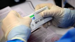 Un trabajador abre una caja de vacuna contra el coronavirus fabricada por una filial de Sinopharm, en una sesión de vacunación a perodistas extranjeros residentes en China, en un centro de vacunación en Beijing, el martes 23 de marzo de 2021.