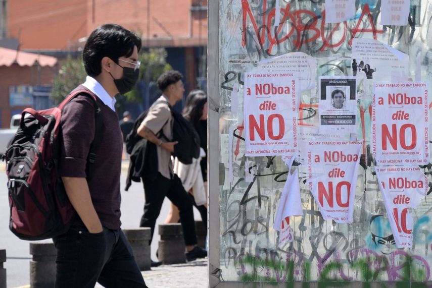 Un estudiante pasa junto a una parada de autobús con carteles en contra del referendo propuesto por el presidente de Ecuador, Daniel Noboa, en el norte de Quito, el 11 de noviembre de 2025.&nbsp;
