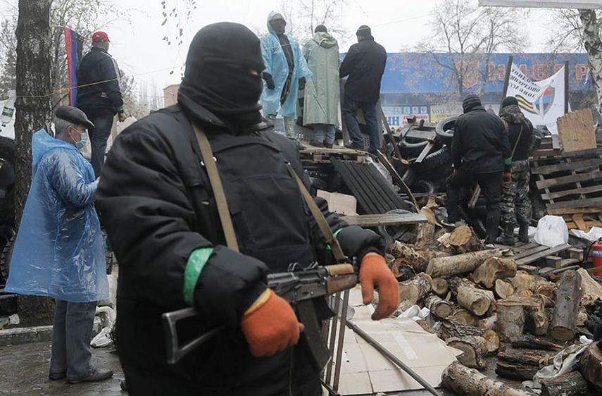 Un militante prorruso resguarda una estación de policía invadida en Slovyansk, en el este de Ucrania, el domingo 13 de abril de 2014. (AP)