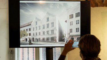 Un periodista toma fotografías de una pantalla que muestra el plan para el rediseño arquitectónico de la casa natal de Adolf Hitler, que será convertida en una estación de policía.&nbsp;