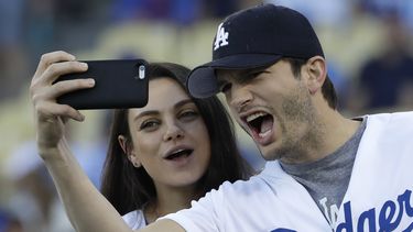 Ashton Kutcher y Mila Kunis se toman un selfie en un juego de béisbol entre los Chicago Cubs y Los Angeles Dodgers.