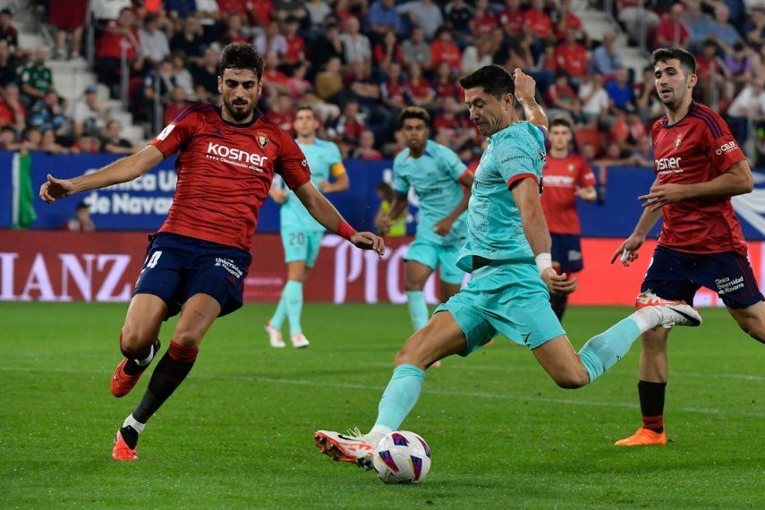 Robert Lewandowski del Barcelona dispara el balón superando a Alejandro Catena del Osasuna en el encuentro de la liga española, el domingo 3 de septiembre del 2023.