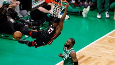 Jimmy Butler del Heat de Miami completa la volcada frente a Jaylen Brown de los Celtics de Boston, el lunes 29 de mayo de 2023.