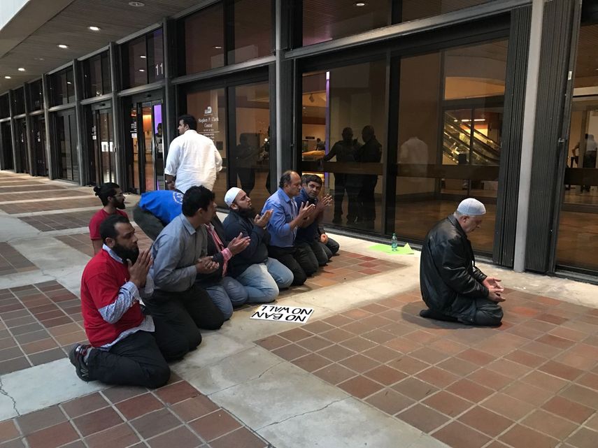Un grupo de musulmanes oran frente a la puerta de entrada a la alcaldía de Miami-Dade.