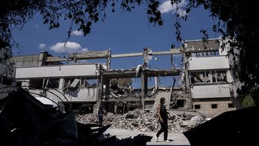 Periodistas ucranianos caminan en el patio de la universidad nacional pedagógica, destruida en un ataque ruso, el miércoles 6 de julio de 2022, en Járkiv, Ucrania.&nbsp;