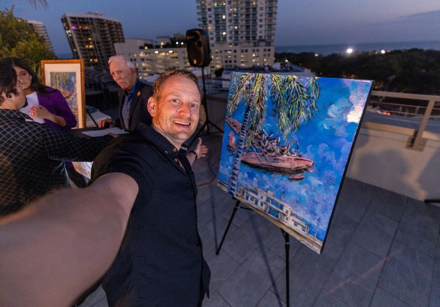 El artista Benjamin Frey se toma un selfie mostrando su obra.&nbsp;