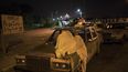 Un hombre duerme sobre su auto mientras espera en una fila para obtener combustible en Maracaibo.