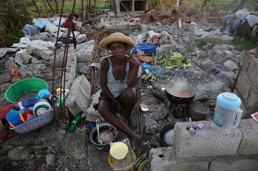 Una haitiana cocina en los restos de su casa totalmente destruida