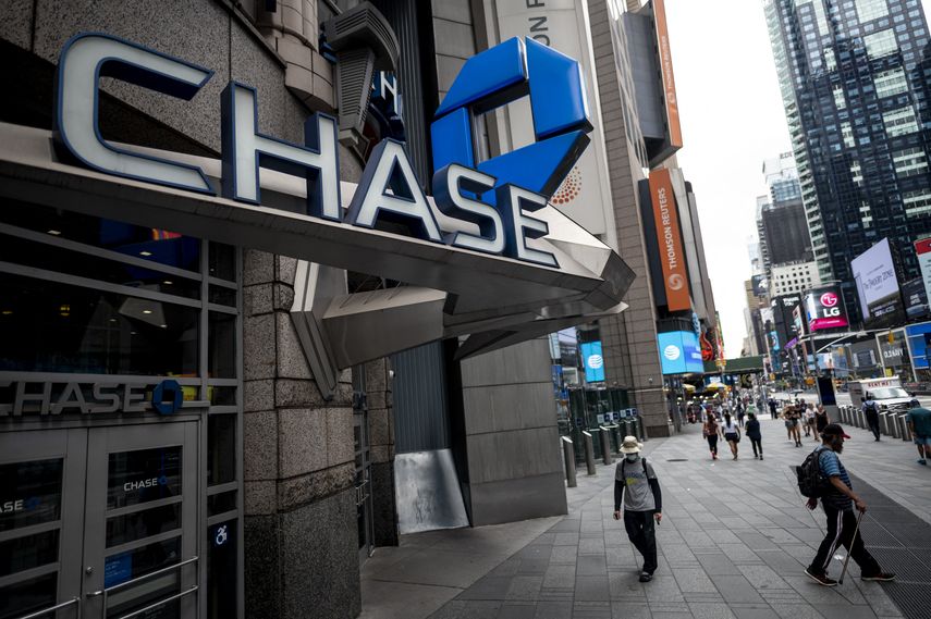 Varias personas caminan frente a un banco Chase.