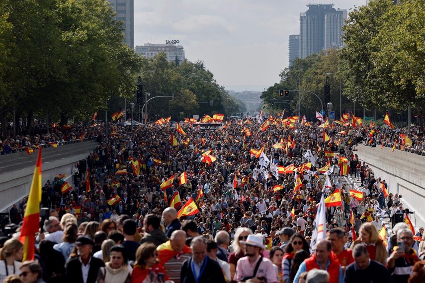 Manifestantes ondean banderas españolas durante una manifestación para protestar contra el gobierno gobernante y exigir elecciones generales, en Madrid el 20 de octubre de 2024.