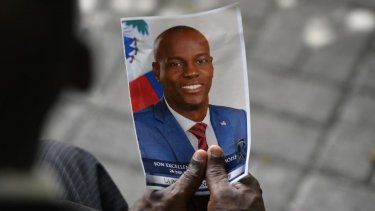 Una persona sostiene una fotografía del presidente haitiano Jovenel Moïse.