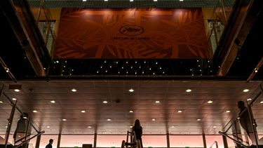 Esta fotografía muestra siluetas en la entrada principal del Palais des Festivals en Cannes, sureste de Francia, el 16 de mayo de 2022 antes del 75° Festival de Cine de Cannes. España será este año el país de honor de la edición del mercado cinematográfico de Cannes.