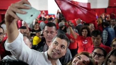 Santiago Peña, presidente electo de Paraguay, se toma una selfie con un simpatizante durante un mitin.